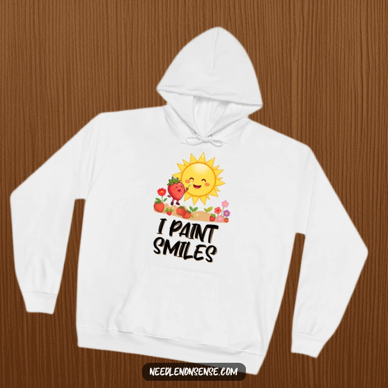Funny hoodie featuring a happy strawberry character happily painting a giant smiling sun with a paintbrush and colorful palette.